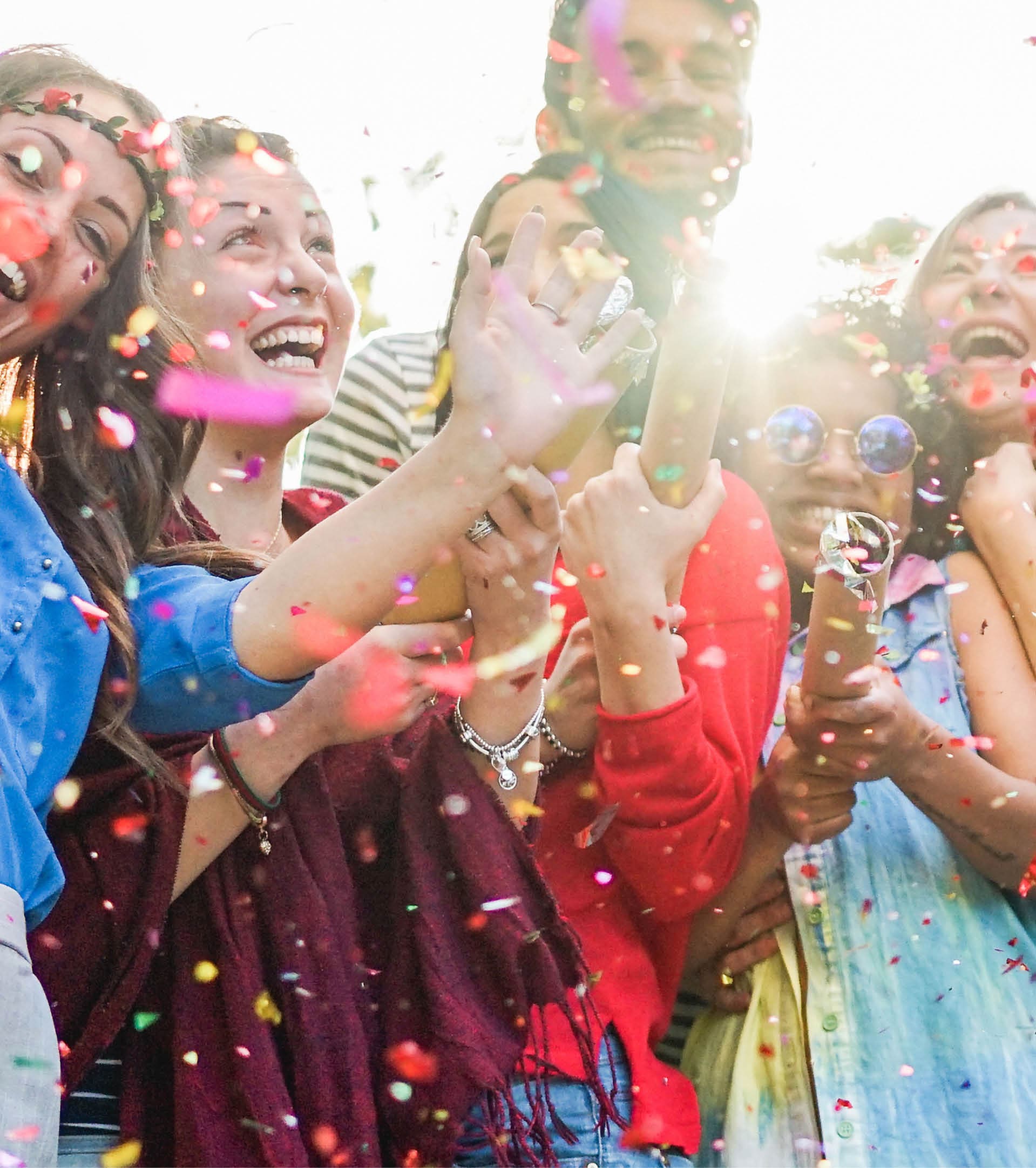 Happy friends having party,throwing confetti and using smoke bombs colors outdoor - Young students laughing and celebrating together - Youth concept - Main focus on three right guys faces 